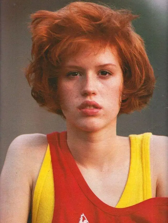 Molly Ringwald in the 80s wearing a yellow tank top with a layered red shirt