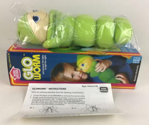 A glowing vintage toy rests on an original box with gloworm instructions on the side.