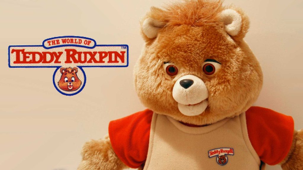 The World of Teddy Ruxpin logo with Teddy Ruxpin wearing a shirt