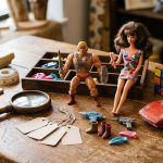 Vintage 1980s toys arranged on a thrift-store table with shopping tools.
