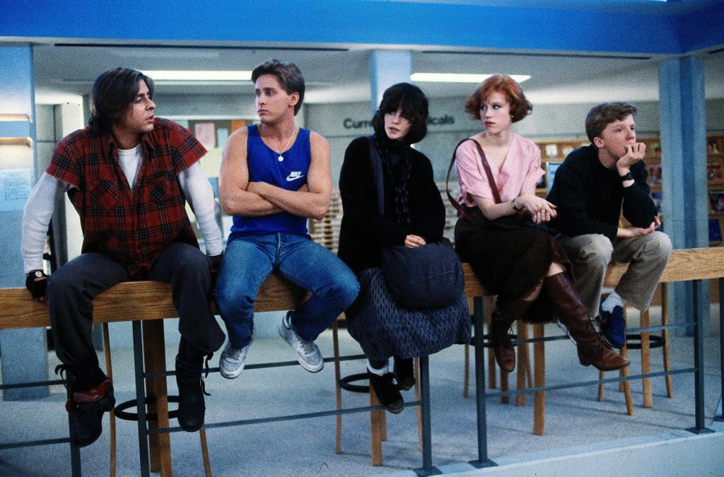 the brat pack sitting on the wooden hand rail of the breakfast club movie